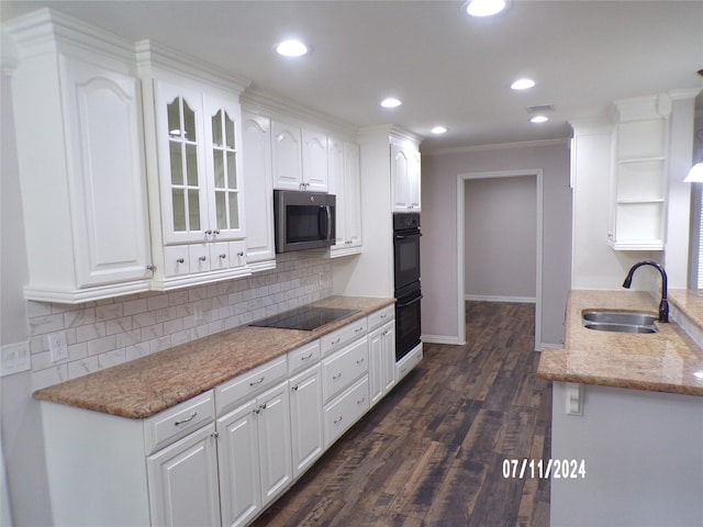 kitchen featuring sink, backsplash, black appliances, and white cabinets