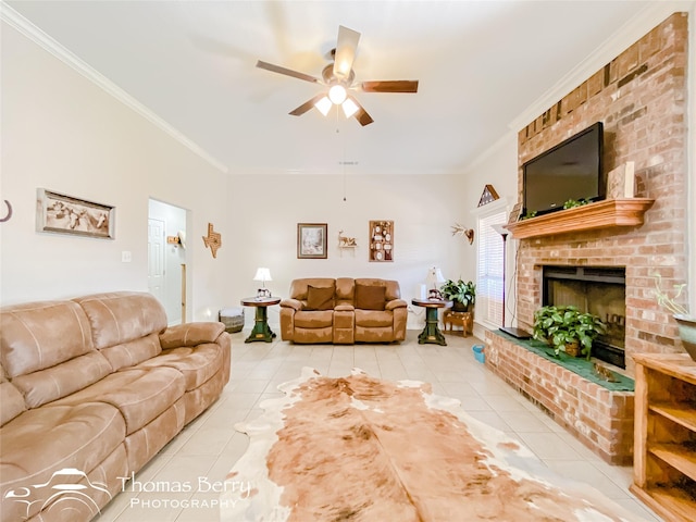 living room featuring light tile patterned flooring, ceiling fan, ornamental molding, and a brick fireplace