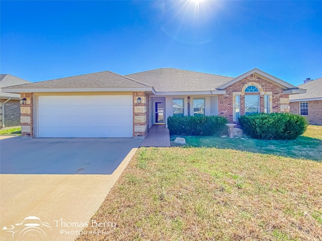 ranch-style home featuring a garage and a front lawn