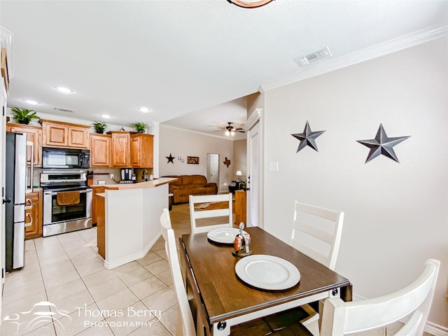 tiled dining area with ornamental molding and ceiling fan