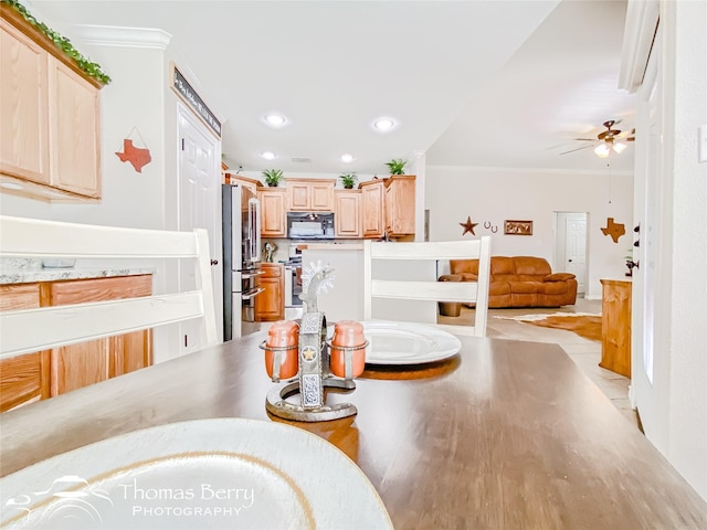 dining space with ornamental molding and ceiling fan