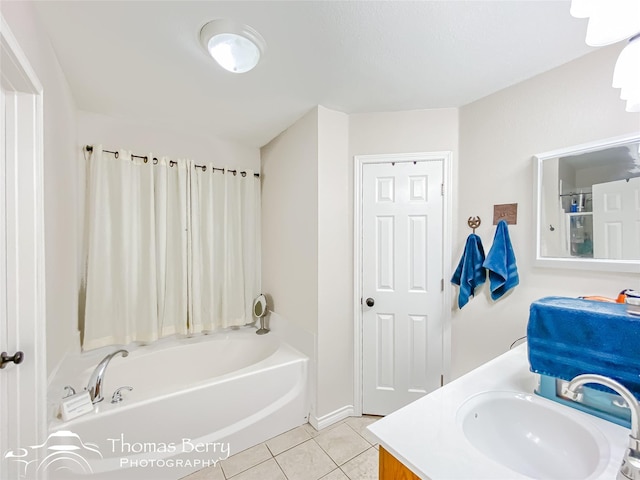 bathroom with tile patterned floors, a bathtub, and vanity