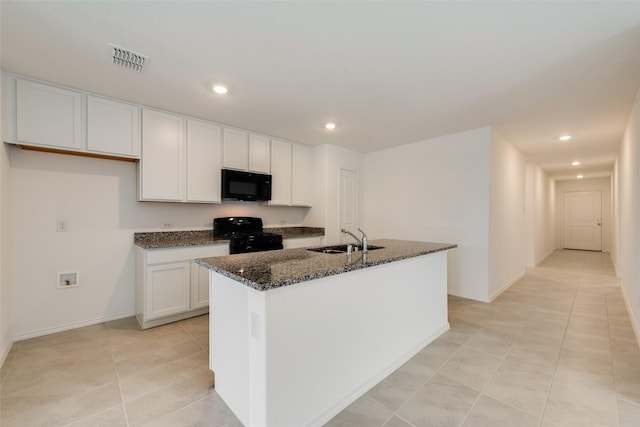 kitchen featuring white cabinetry, a center island with sink, black appliances, sink, and dark stone counters