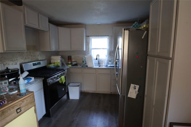 kitchen featuring stainless steel appliances, dark hardwood / wood-style flooring, sink, and white cabinets