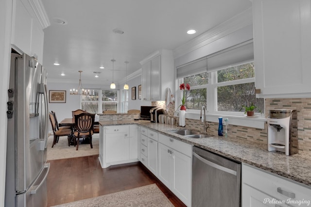 kitchen featuring white cabinetry, stainless steel appliances, decorative light fixtures, and sink