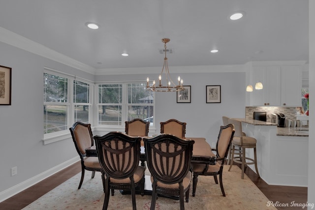 dining area featuring dark wood-type flooring, a healthy amount of sunlight, and ornamental molding