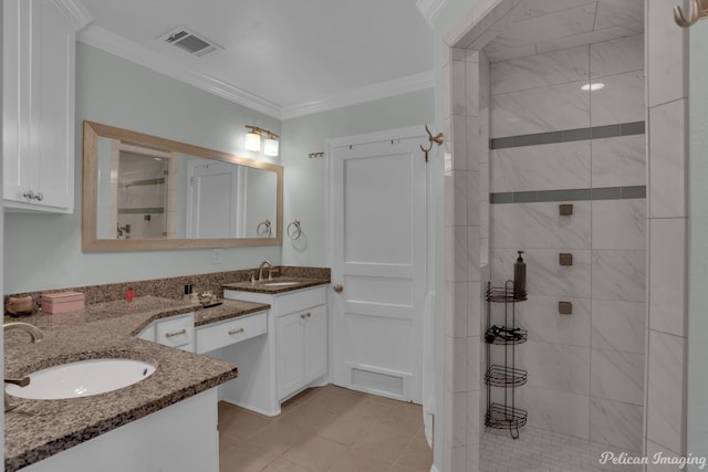 bathroom featuring crown molding, tile patterned floors, vanity, and a tile shower