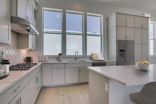 kitchen featuring ornamental molding, stainless steel appliances, sink, and plenty of natural light