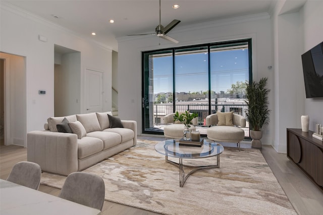 living room with crown molding, light hardwood / wood-style floors, and ceiling fan