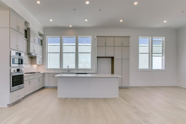 kitchen with a healthy amount of sunlight, a kitchen island, and gray cabinetry