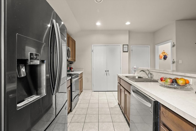 kitchen featuring stainless steel appliances, sink, and light tile patterned floors