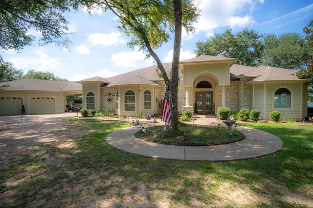 view of front of home with a garage, a front yard, and french doors