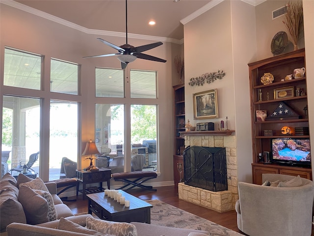 living room with a fireplace, ornamental molding, dark hardwood / wood-style floors, and plenty of natural light