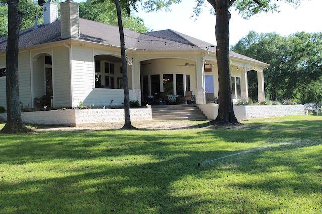 rear view of property featuring ceiling fan, a yard, and a patio area