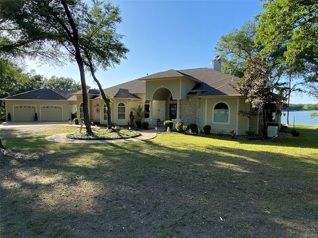 view of front facade with a garage, a water view, and a front yard