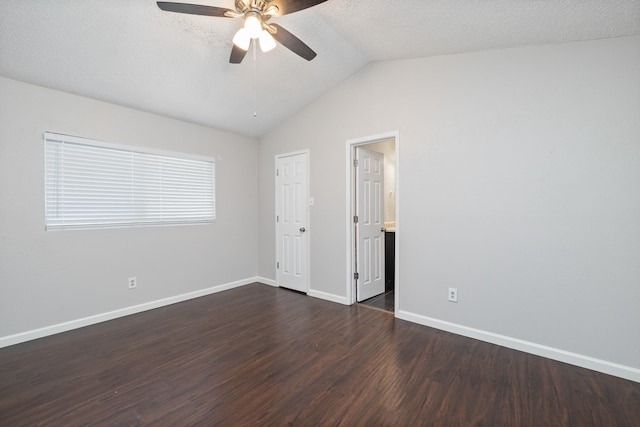 unfurnished bedroom with ensuite bath, dark wood-type flooring, ceiling fan, a textured ceiling, and vaulted ceiling