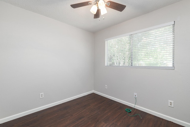 empty room featuring ceiling fan, a textured ceiling, and dark hardwood / wood-style flooring