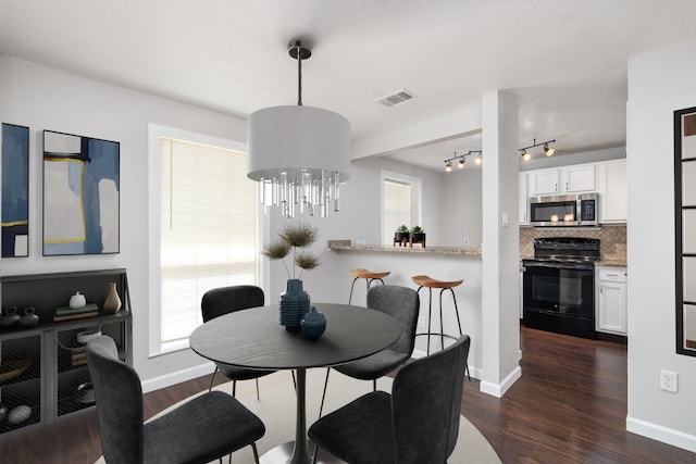 dining space with a notable chandelier and dark hardwood / wood-style flooring