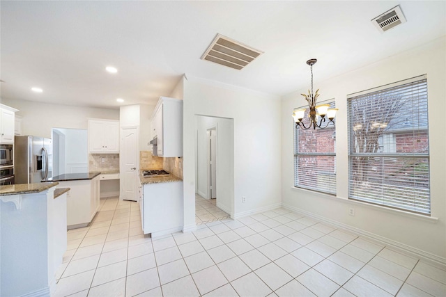 kitchen with white cabinetry, hanging light fixtures, light tile patterned floors, stainless steel appliances, and decorative backsplash