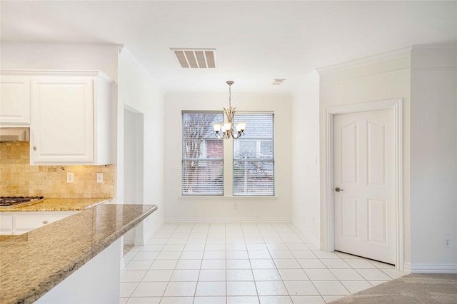 unfurnished dining area with ornamental molding, light tile patterned floors, and a notable chandelier