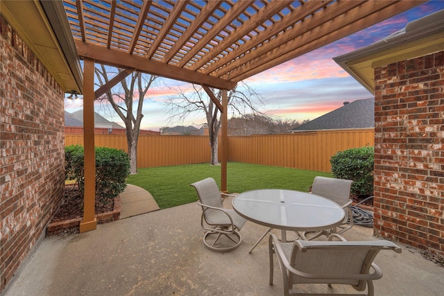 patio terrace at dusk featuring a yard and a pergola