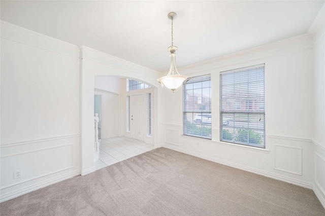 empty room with ornamental molding and light carpet