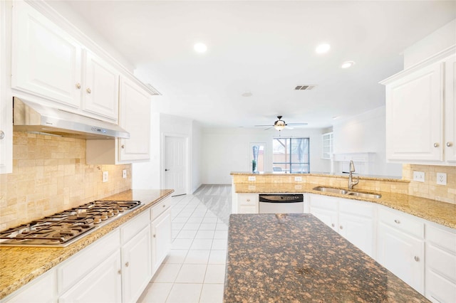 kitchen with sink, light tile patterned floors, appliances with stainless steel finishes, kitchen peninsula, and white cabinets