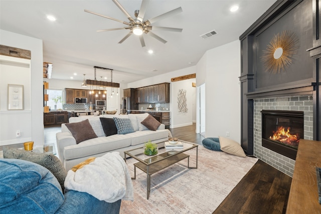 living room with ceiling fan, dark hardwood / wood-style floors, and a fireplace