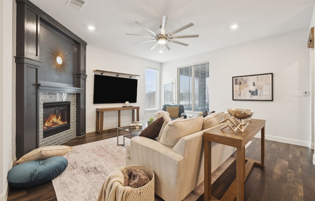 living room featuring a fireplace, dark hardwood / wood-style floors, and ceiling fan