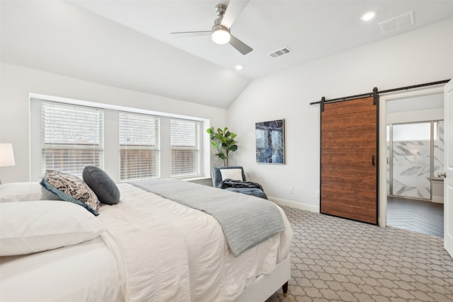 carpeted bedroom with ceiling fan, a barn door, and vaulted ceiling