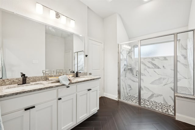 bathroom with parquet flooring, vanity, a shower with shower door, and vaulted ceiling