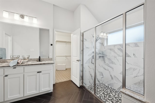 bathroom with vanity, parquet flooring, and walk in shower