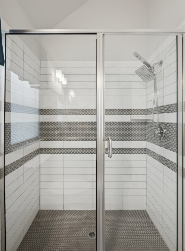 bathroom with lofted ceiling and a shower with door