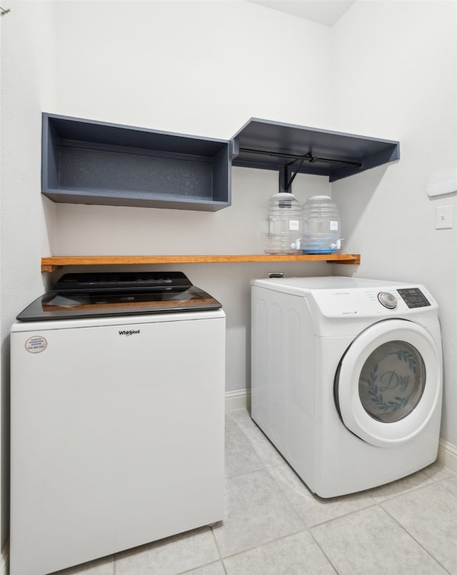 laundry room with light tile patterned flooring and washer and clothes dryer