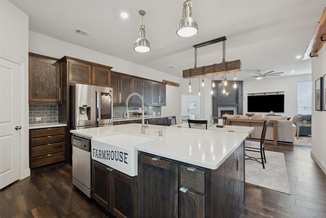 kitchen with sink, dark brown cabinets, a center island with sink, and appliances with stainless steel finishes