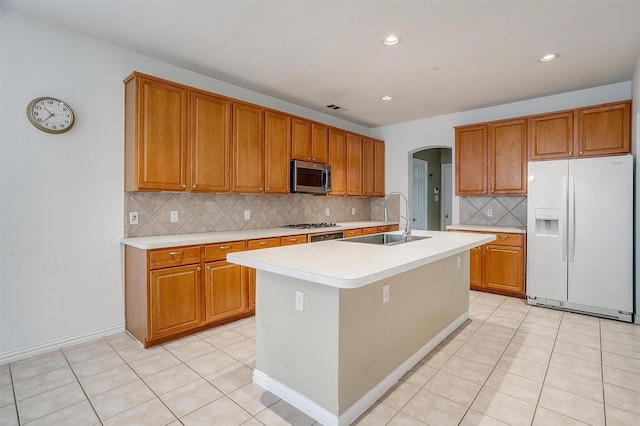 kitchen featuring stainless steel appliances, sink, a center island with sink, and light tile patterned floors