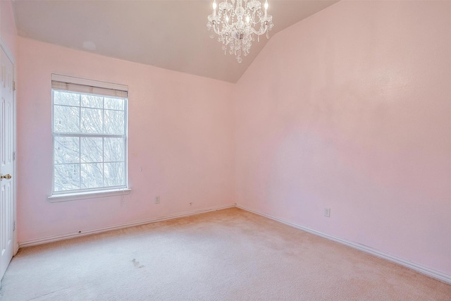 carpeted empty room featuring an inviting chandelier and lofted ceiling