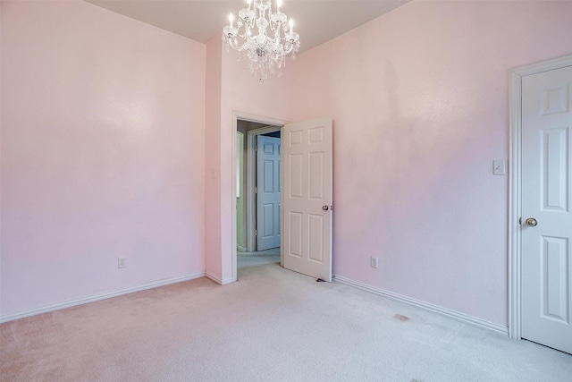 carpeted spare room with a chandelier