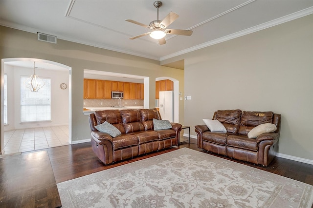 living room with crown molding, ceiling fan, and wood-type flooring