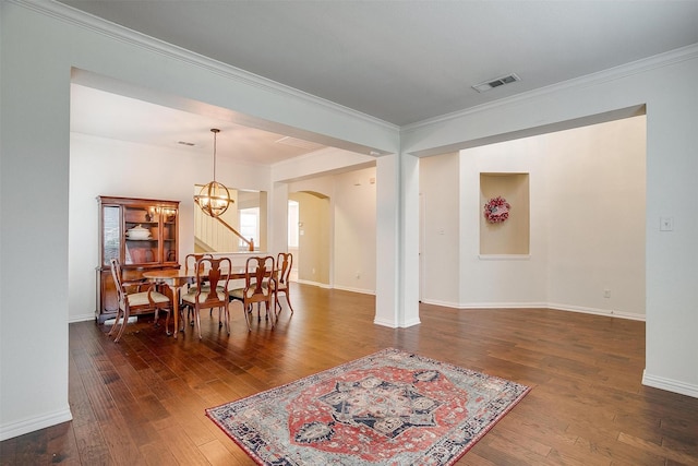 dining space featuring an inviting chandelier, dark hardwood / wood-style flooring, and crown molding