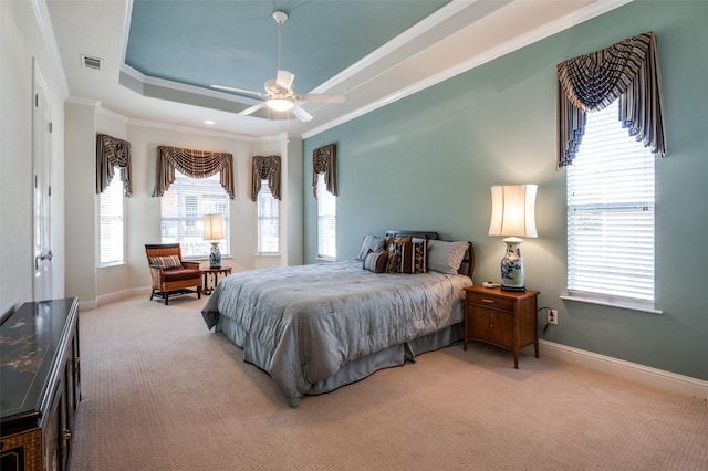 bedroom featuring ornamental molding, light carpet, ceiling fan, and a tray ceiling