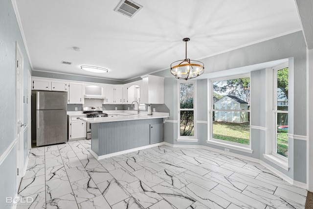 kitchen featuring white cabinetry, crown molding, hanging light fixtures, appliances with stainless steel finishes, and kitchen peninsula