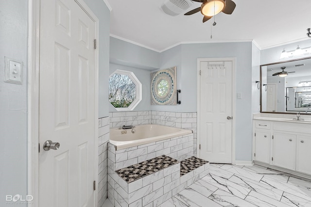 bathroom with tiled tub, crown molding, vanity, and ceiling fan