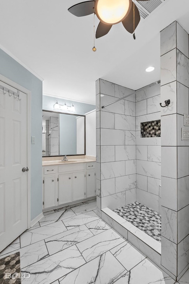 bathroom with ceiling fan, vanity, and a tile shower