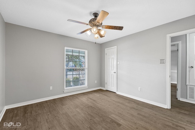 empty room featuring ceiling fan and dark hardwood / wood-style flooring