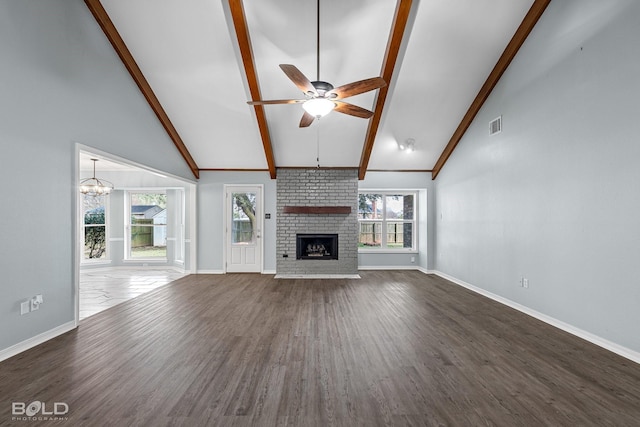 unfurnished living room featuring dark wood-type flooring, high vaulted ceiling, a fireplace, ceiling fan with notable chandelier, and beamed ceiling