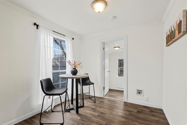 dining area featuring crown molding and dark wood-type flooring