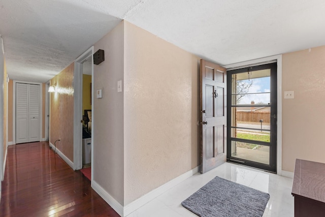 entrance foyer featuring wood-type flooring, floor to ceiling windows, and a textured ceiling