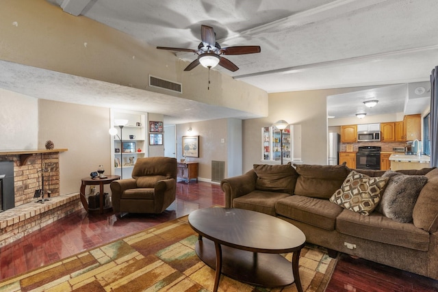 living room with ceiling fan, a textured ceiling, and dark hardwood / wood-style flooring