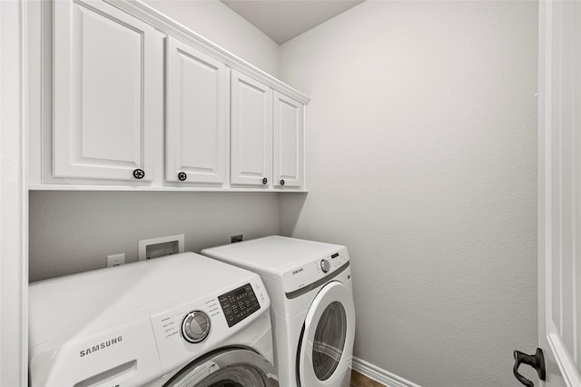 laundry room with separate washer and dryer and cabinets